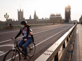 A cyclist wearing a face mask rides across a near-deserted Westminster Bridge in London, England, on April 8, 2020. (Photo by David Cliff/NurPhoto via Getty Images)