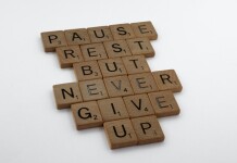 A wooden block puzzle with the motivating words "pause, rest, but never give up"